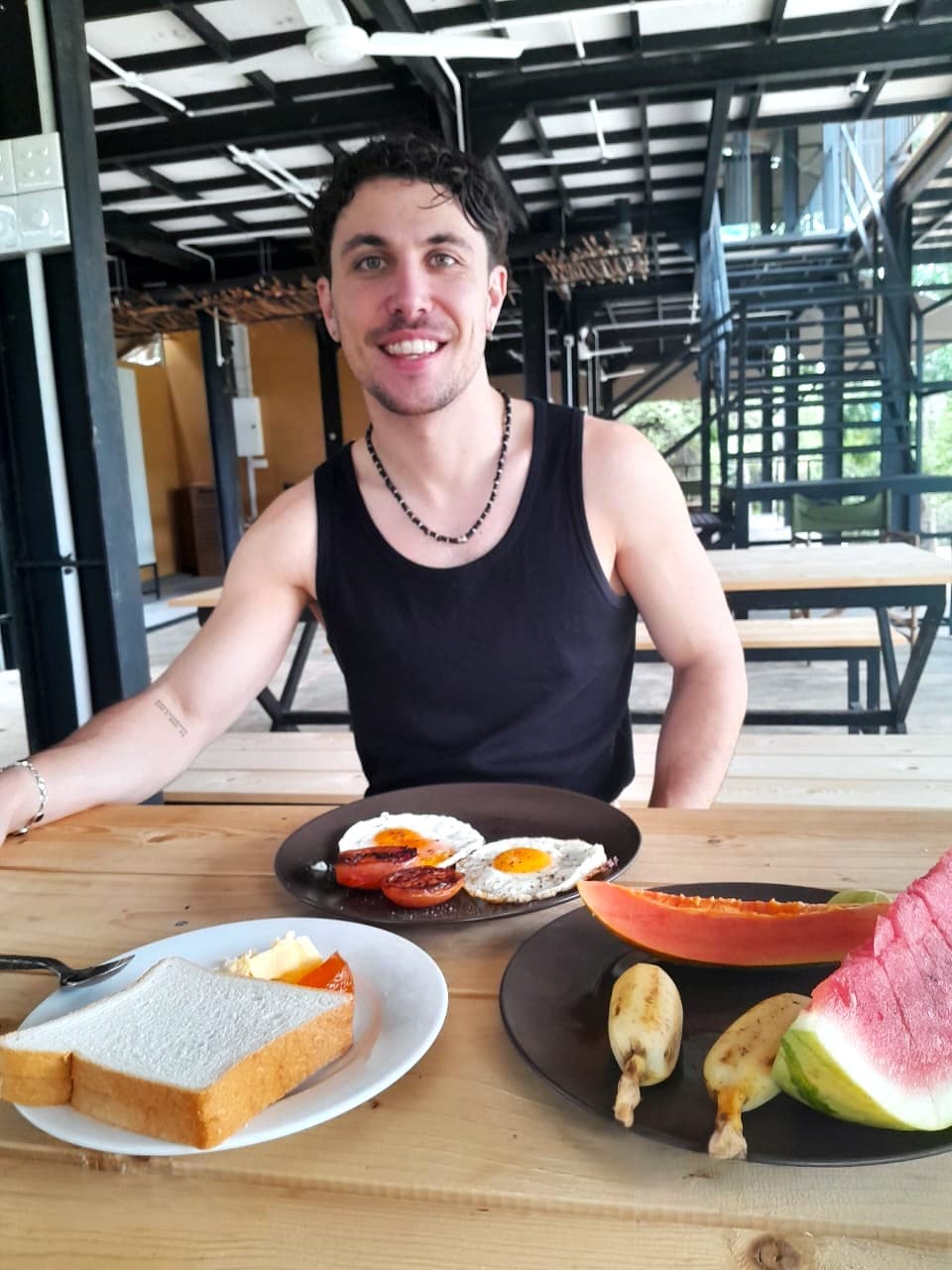 A guest at the breakfast table with a plate of eggs and cut fruit