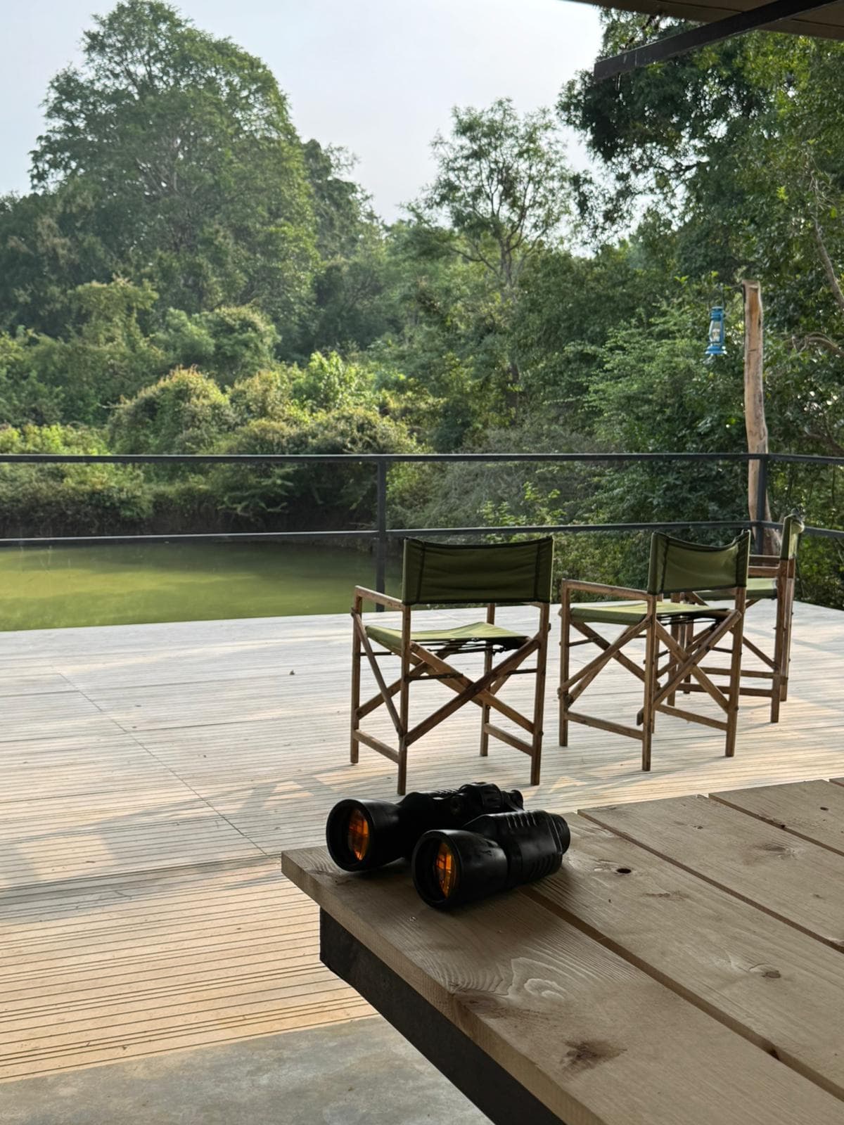 Binoculars resting on the deck table with directors chairs facing the water